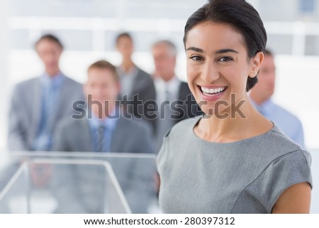 Smiling businesswoman looking at camera during conference in meeting room