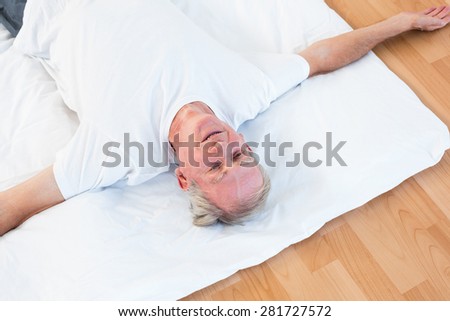 Old man relaxing with open eyes in gym