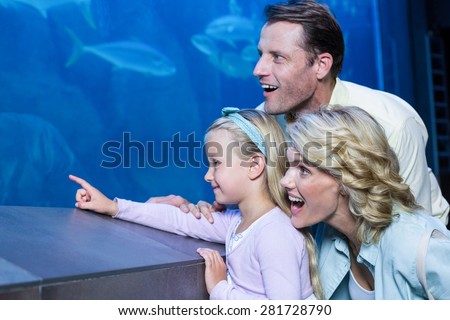 Happy family looking at the fish tank at the aquarium