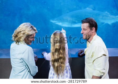 Happy family looking at the fish tank at the aquarium