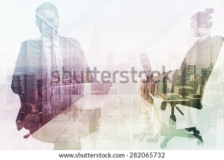 Happy businessman with laptop using smartphone against server room with towers