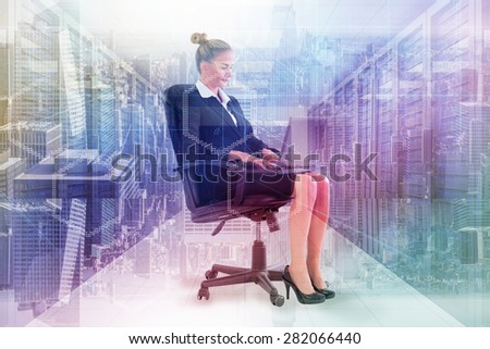 Businesswoman sitting on swivel chair with laptop against server room with towers