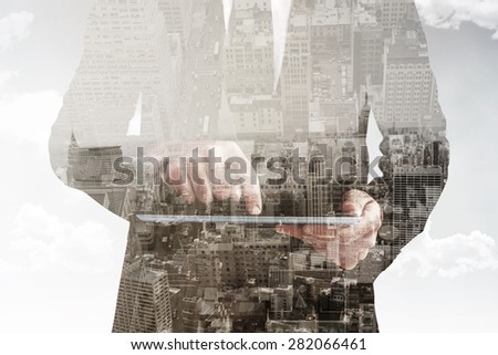 Businessman using his tablet pc against new york skyline