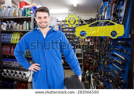 Smiling male mechanic holding tire against full store room