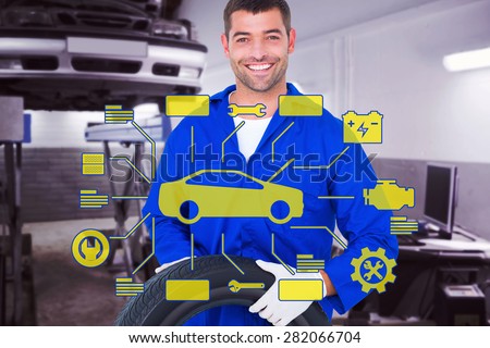 Mechanic holding tire on white background against auto repair shop