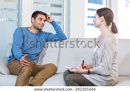 Psychologist talking with happy man in the office