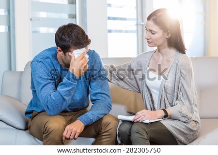 Psychologist comforting a depressed man in the office