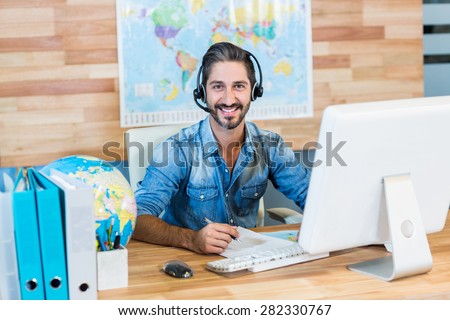 Smiling travel agent looking at camera in the office