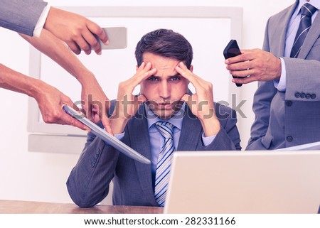 Worried businessman with head in hands sitting at the office