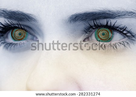 Close up of female blue eyes against spiral