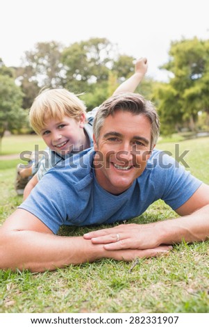 Happy father and his son smiling at camera on a sunny day