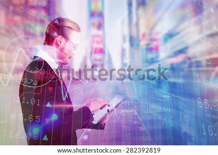 Businessman in reading glasses using his tablet pc against blurry new york street