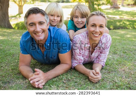 Happy family smiling at the camera on a sunny day