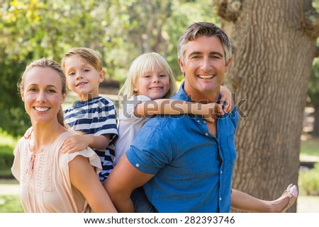 Happy family playing in the park together on a sunny day