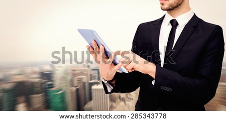 Mid section of a businessman using digital tablet pc against new york