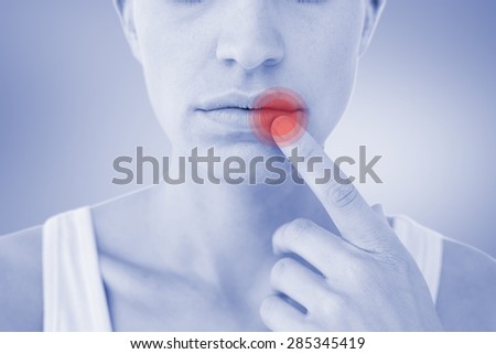 Pretty woman with finger on lip against grey vignette