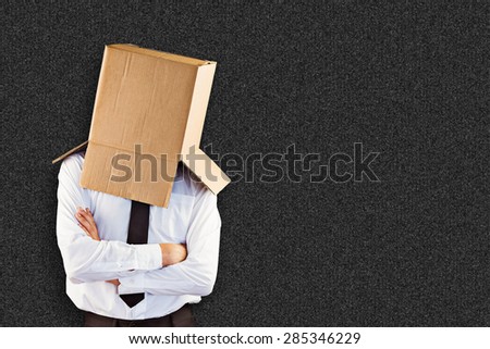 Anonymous businessman with arms crossed against black background