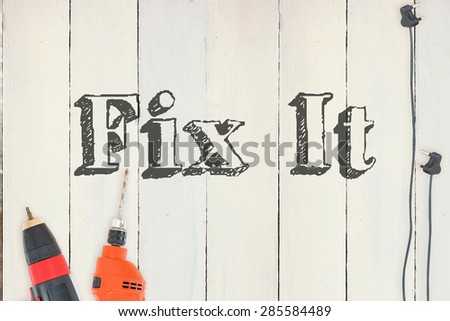 The word fix it against diy tools on wooden background