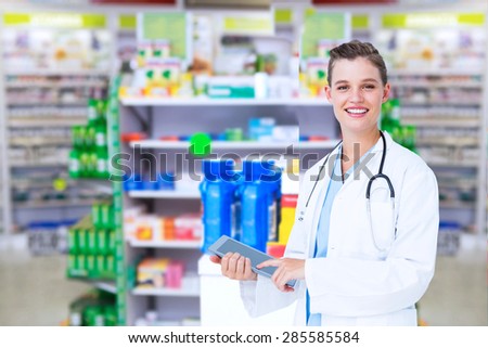 Happy doctor holding tablet pc against close up of shelves of drugs