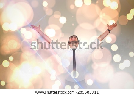 Cheering businessman with his arms raised up against white glowing dots on grey