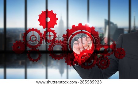Unsmiling businessman pointing his finger against room with large window looking on city