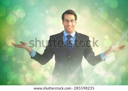 Businessman with open hands looking at the camera against green abstract light spot design