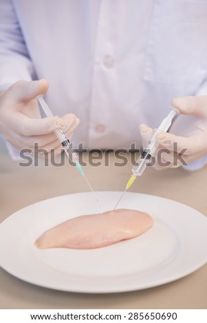 Scientist injecting piece of meat in the laboratory