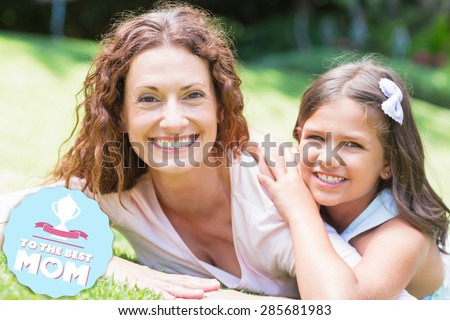 mothers day greeting against happy mother and daughter lying on the grass