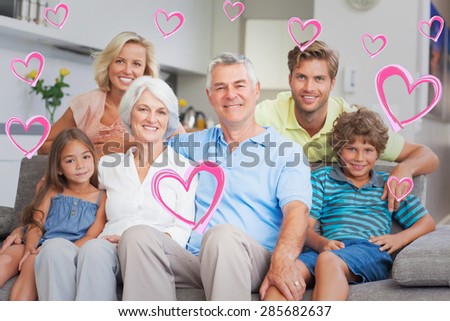 Multigeneration family posing in the living room against red hearts