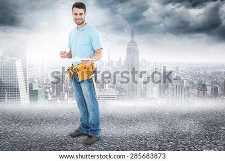 Smiling construction worker holding clipbard against black road