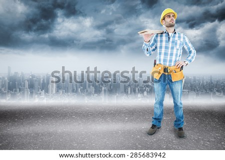 Thoughtful worker carrying wooden planks against road