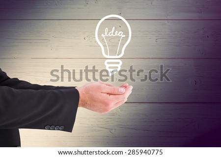 Businessman holding something with his hands against shadow on wooden boards