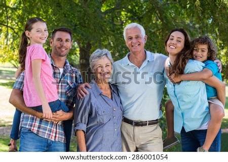 Extended family smiling at the camera on a sunny day