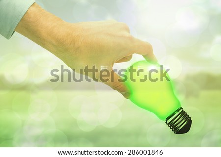 Businessman measuring something with these fingers against green abstract light spot design