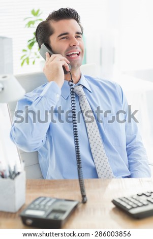 Businessman laughing on the phone in the office