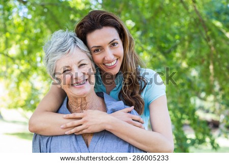 mother and grandmother smilling in a park on a sunny day