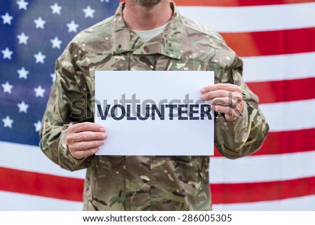 American soldier holding recruitment sign against american flag