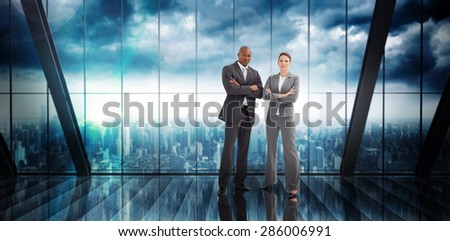 Confident business team against room with large window looking on city