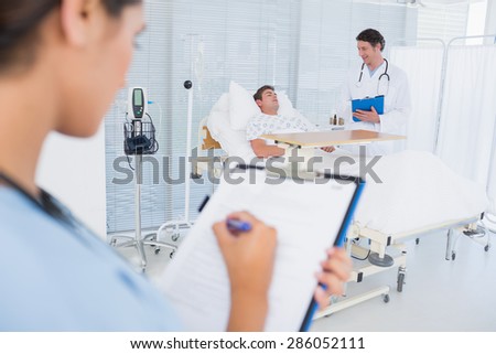 Doctors taking care of patient in hospital room