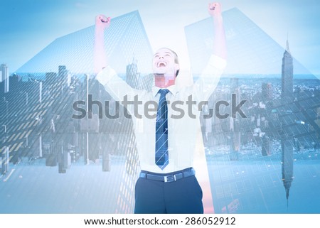 Handsome businessman cheering with arms up against mirror image of city skyline
