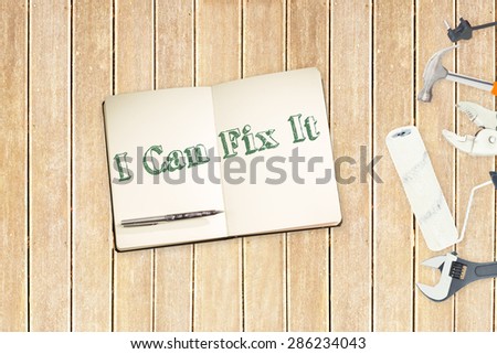 The word i can fix it against tools and notepad on wooden background