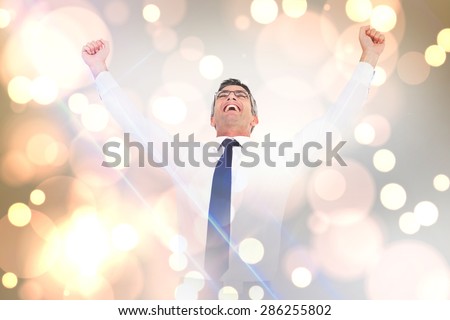 Excited businessman with glasses cheering against white glowing dots on grey