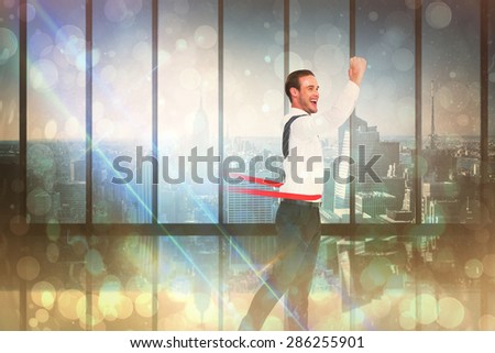 Businessman crossing the finish line against room with large window looking on city