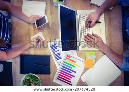 Creative workers sharing desk in creative office