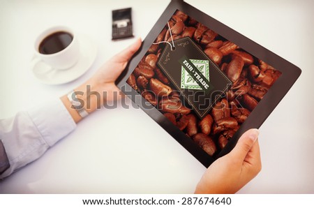 Man using tablet pc against fair trade label on coffee