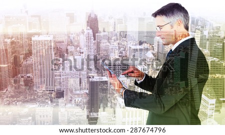 Mid section of a businessman touching tablet against room with large window looking on city