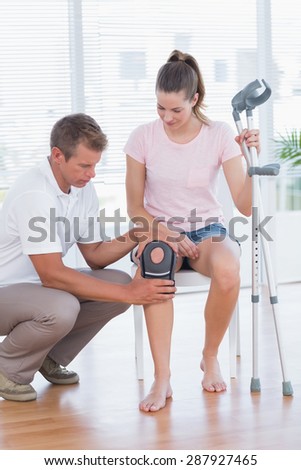Doctor examining his patient knee in medical office