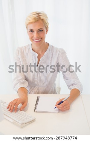 Portrait smiling blonde woman using computer in the office