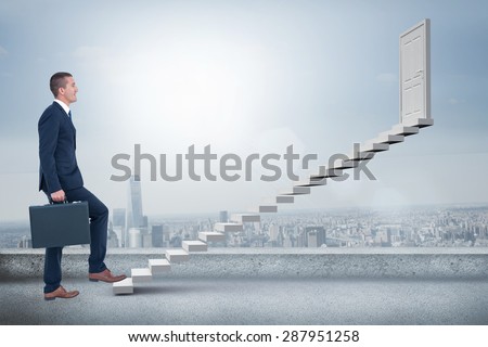 Businessman climbing with briefcase against cityscape