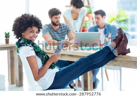 Young casual woman with feet on the table in the office